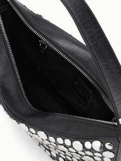 Close-up of an open STAUD Demy Shoulder Bag in Rivets, crafted from black nappa leather with silver studs, displaying the interior zippered pocket and fabric lining.