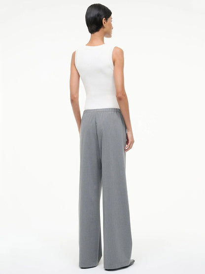A person stands facing away, wearing a sleeveless white top and the STAUD Denali Pant in Static, a loose-fitting pull-on style, against a plain white background.
