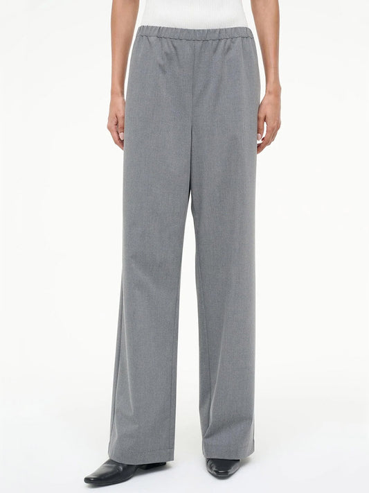Person wearing the STAUD Denali Pant in Static, a gray, loose-fitting, straight-leg pull-on style with an elastic waistband, paired with black shoes and a white top.