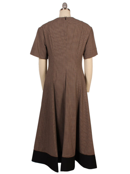 The STAUD Frances Short Sleeve Dress in Houndstooth features a split neck, fitted waist, A-line skirt, black hem, short sleeves, and a back zipper, shown here on a dress form.