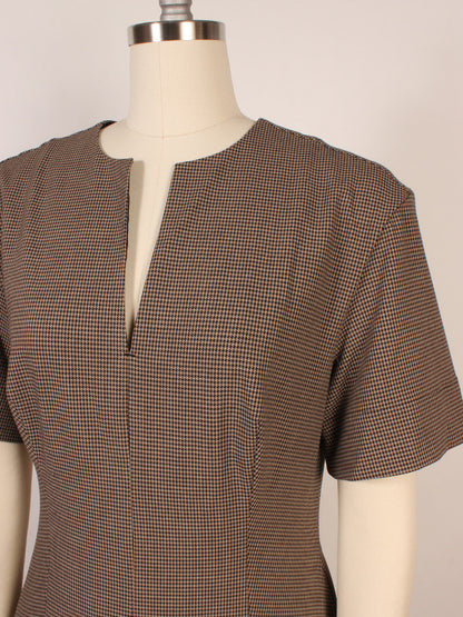 A close-up of a mannequin wearing the STAUD Frances Short Sleeve Dress in houndstooth cotton poplin, featuring short sleeves, an A-line skirt, and a front notch neckline.