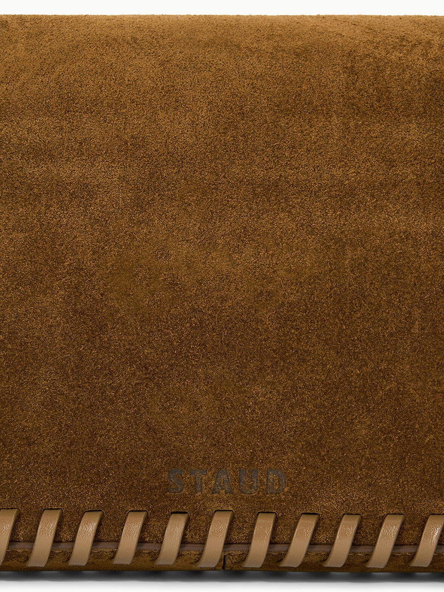 STAUD Harlow Bag in Cigar, a brown suede shoulder bag with whipstitch detailing along the bottom edge.