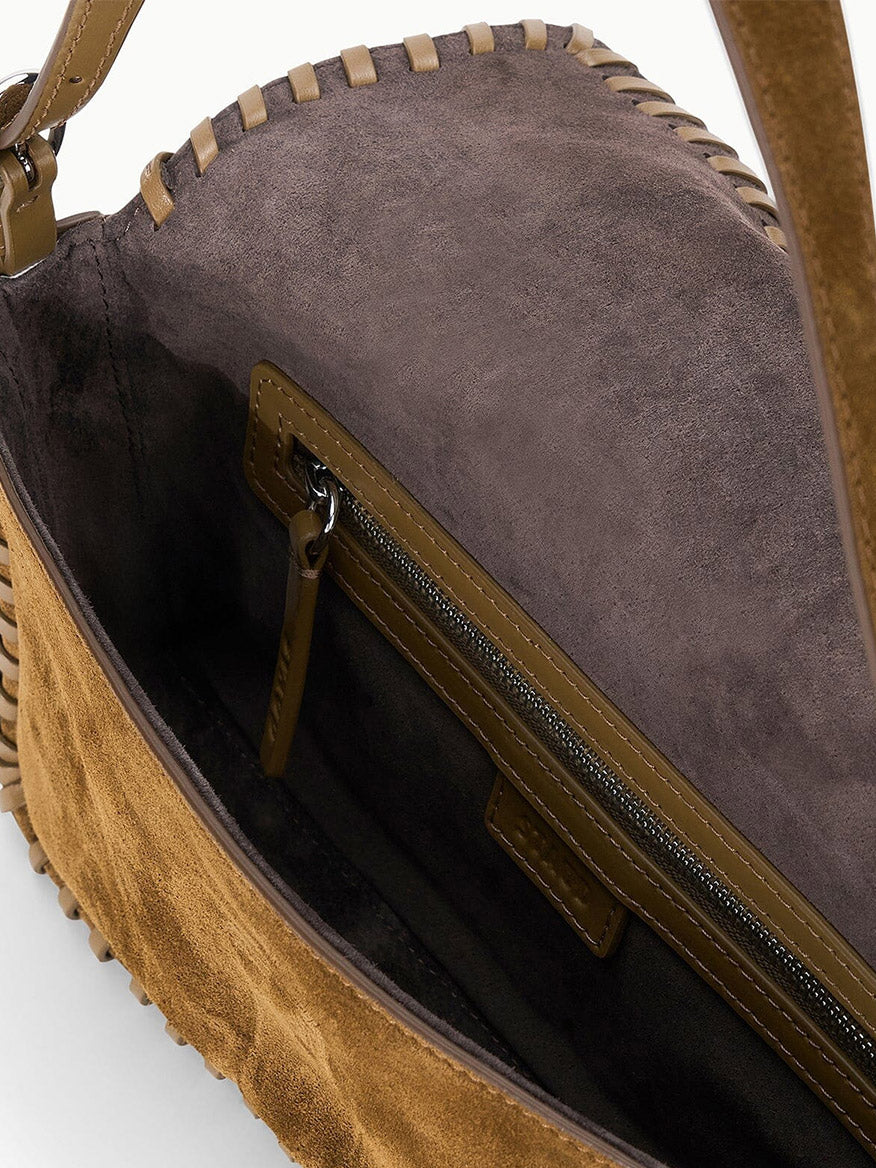 Interior of a brown suede STAUD Harlow Bag in Cigar with whipstitch detailing, featuring a zippered pocket.