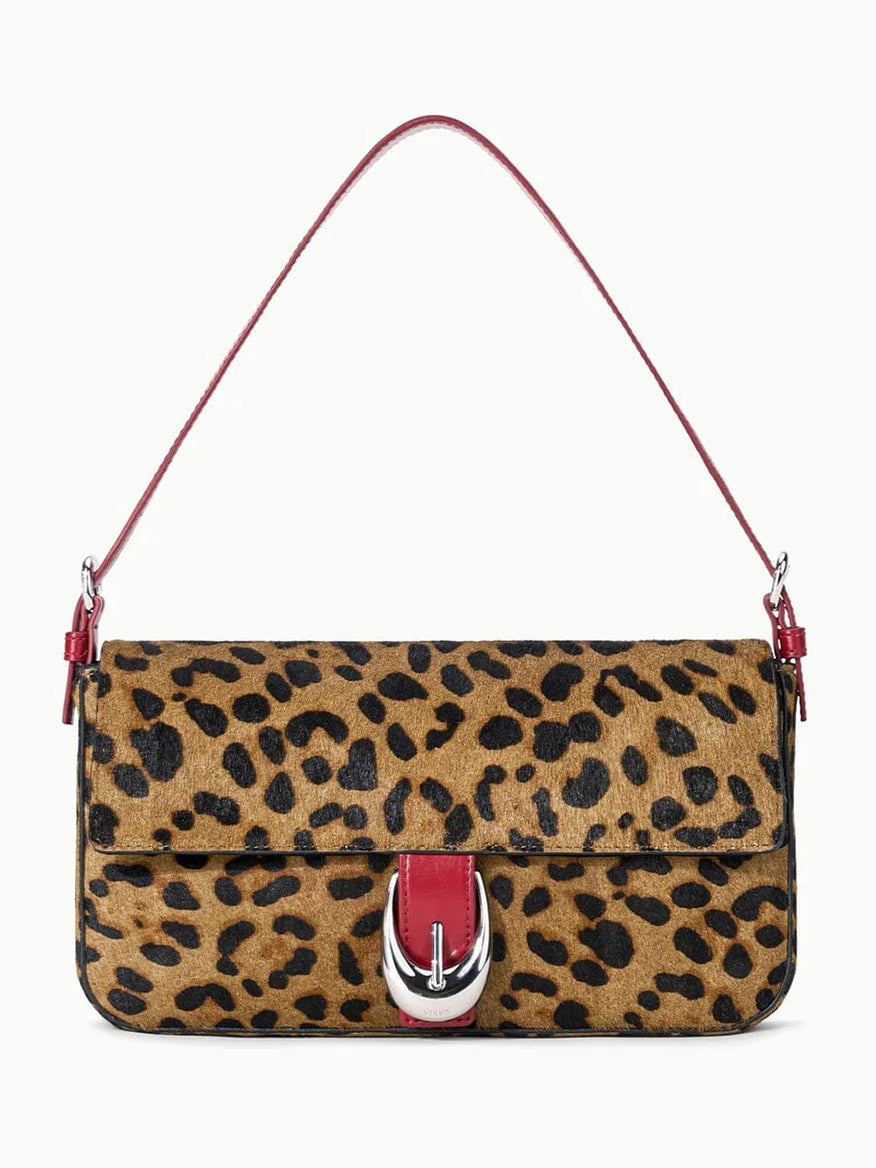 STAUD Harlow Bag in Cheetah, crafted from luxurious haircalf, features a striking red strap and a signature Moon buckle detail on the front flap. This rectangular bag includes a short shoulder strap for easy carrying.