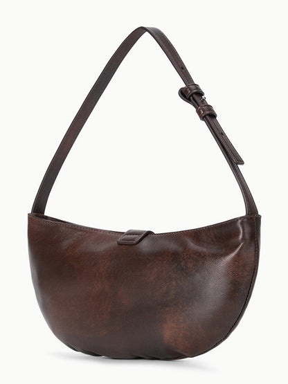 STAUD Harlow Crescent Shoulder Bag in Espresso Distressed, featuring an adjustable strap, simple curved silhouette, and a small tab closure at the top, is displayed against a plain white background.
