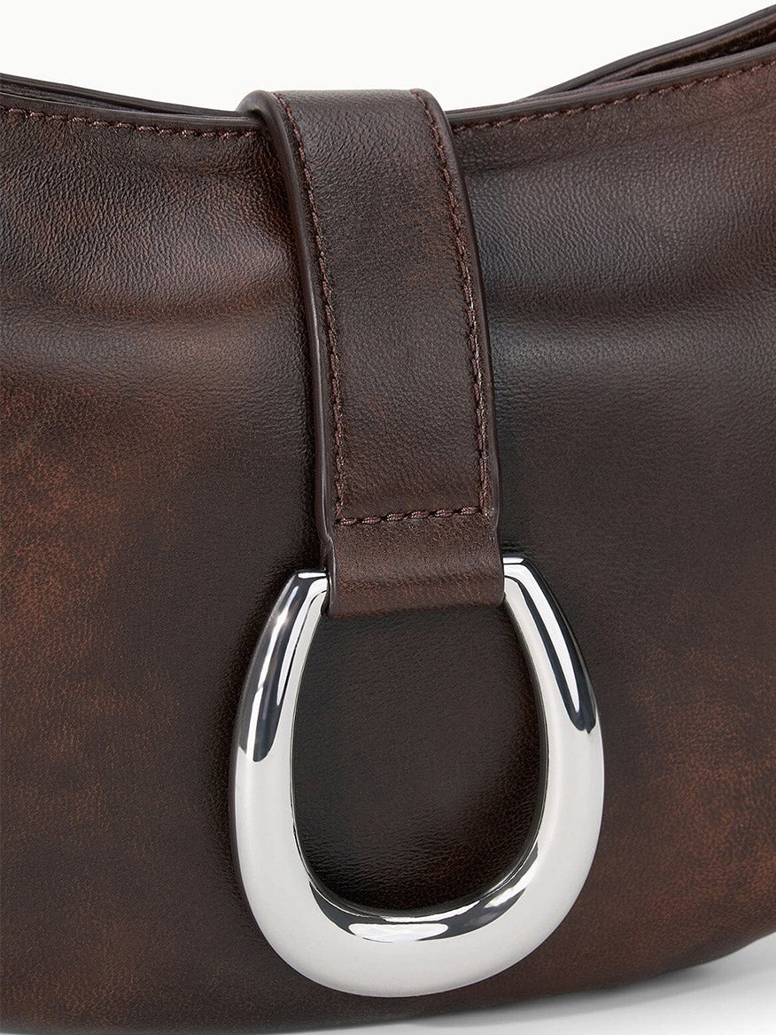 Close-up of the STAUD Harlow Crescent Shoulder Bag in Espresso Distressed, showcasing its dark brown distressed leather and a strap with a prominent silver crescent moon buckle detail.