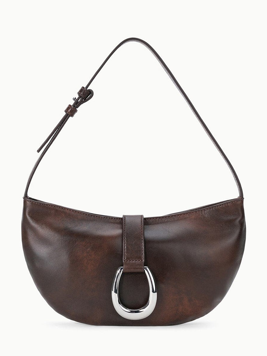 The STAUD Harlow Crescent Shoulder Bag in Espresso Distressed features rich distressed leather in deep brown, accented by a single strap and a metallic moon buckle on its minimalist front flap for enduring appeal.