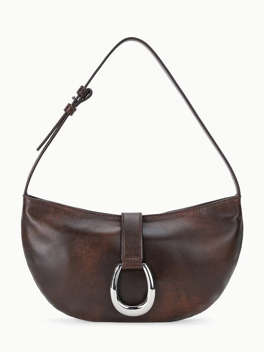 The STAUD Harlow Crescent Shoulder Bag in Espresso Distressed features rich distressed leather in deep brown, accented by a single strap and a metallic moon buckle on its minimalist front flap for enduring appeal.