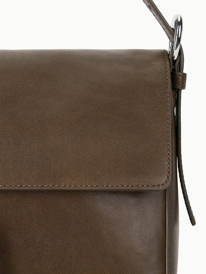 Close-up of the STAUD Harlow Medium Bag in Truffle, a brown leather shoulder bag featuring a flap closure, visible stitching, and an elegant Moon buckle.