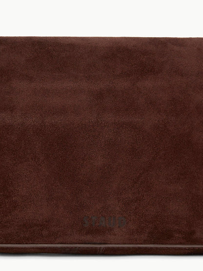A close-up of the STAUD Harlow Bag in Mahogany Suede, featuring the brand name embossed near the bottom center and showcasing signature chic details.