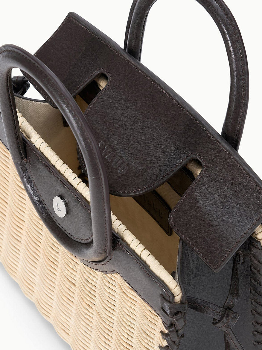The STAUD Maude Mini Wicker Carryall in Natural/Espresso features woven beige and dark brown leather, an open top, visible handle, and interior details—offering versatile style for any occasion.