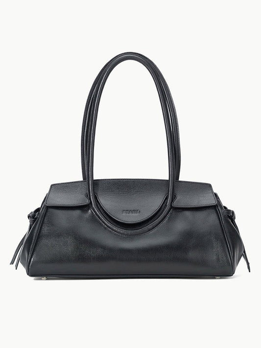 The STAUD Maude Shoulder Bag in Black is crafted from polished leather with double rounded handles and a flap closure, showcasing an elegant east-west silhouette against a plain white background.