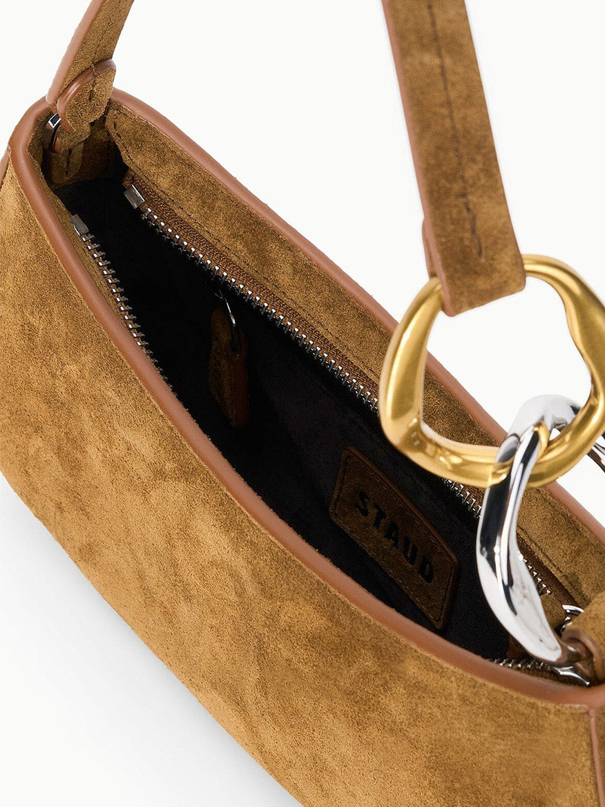 STAUD Ollie Bag in Cigar: a compact brown suede shoulder bag with a zipper closure and asymmetrical gold and silver metal ring hardware.