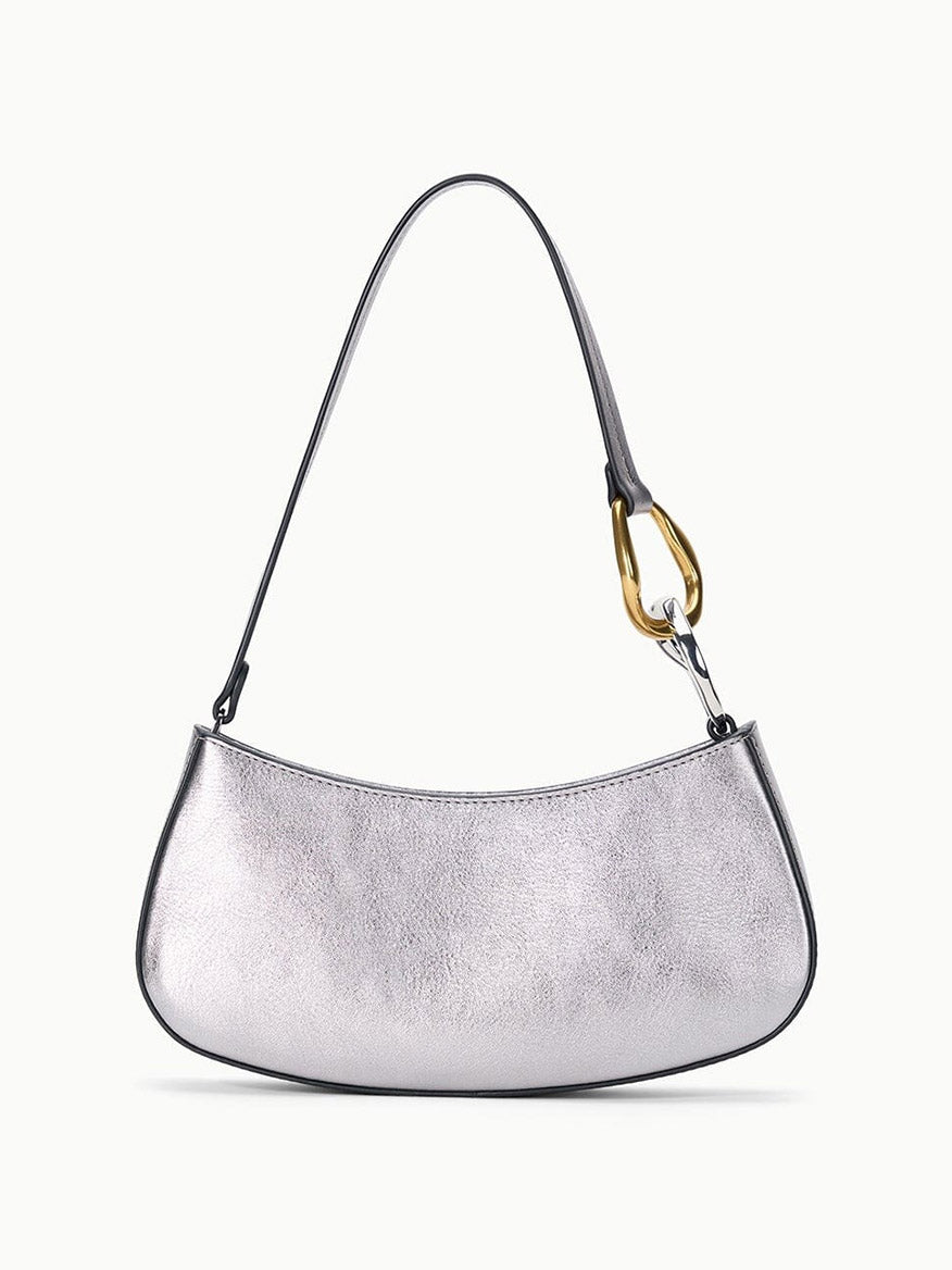 The STAUD Ollie Bag in Pewter is a silver, crescent-shaped mini shoulder bag with a single strap and eye-catching two-tone hardware, including a gold-tone metal accent on one side.