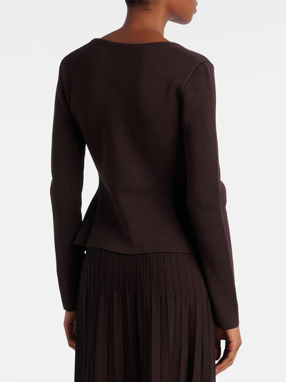 A person is shown from the back wearing the STAUD Rachela Sweater in Earth, a long-sleeved dark brown knit top with a notched square neck, paired with a matching pleated skirt against a plain background.