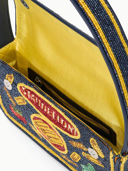 A close-up of the STAUD Tommy Beaded Bag in Staudelloni, an open limited-edition vegan leather handbag with a yellow interior, zippered pocket, and colorful embroidered exterior designs.