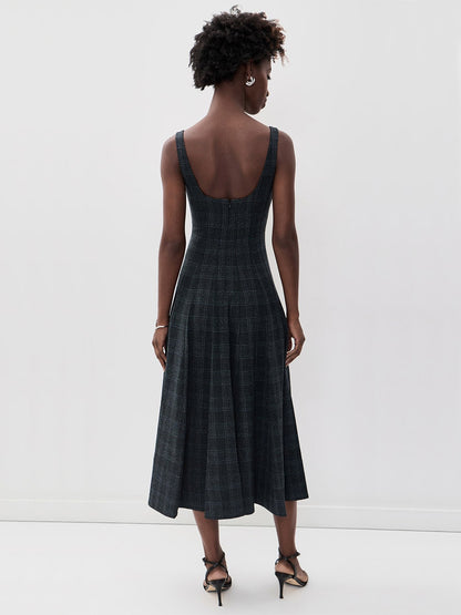 Back view of a STAUD Wells Midi Sleeveless Dress in Ink Blue Plaid, featuring a sleeveless, midi-length design with a scoop back, fitted waist, and pleated skirt.