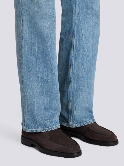A person wearing light blue jeans and Santoni Desert Lace Up Boot in Grey Suede stands on a light gray surface.