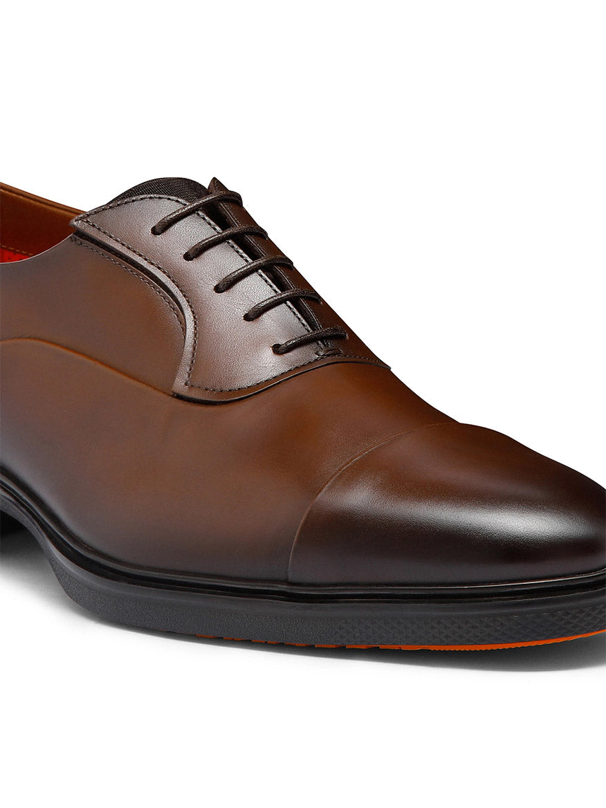 A close-up of the Santoni Easy Lace-Up Oxford in Dark Brown, showcasing its cap toe and Italian craftsmanship, set against a white background.