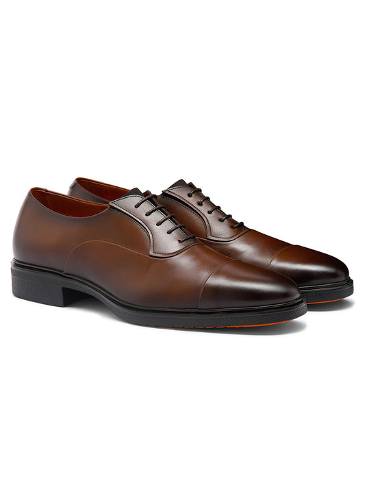The Santoni Easy Lace-Up Oxford in Dark Brown features premium leather, cap toes, black soles, and Italian craftsmanship, elegantly displayed against a white background.