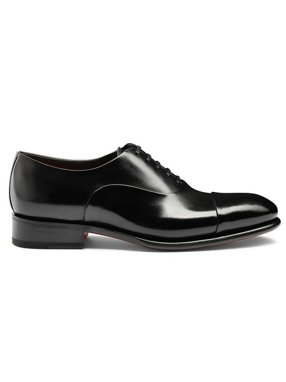 The Santoni Isaac Balmoral Oxford in Black is a side-viewed shoe with a black cap toe, black sole, crafted from high-quality leather using Goodyear construction for lasting durability.