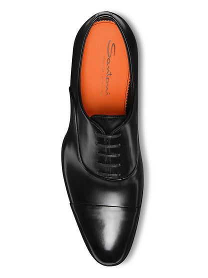 A top view of the Santoni Isaac Balmoral Oxford in Black, a premium leather lace-up dress shoe with an orange "Santoni" branded insole.