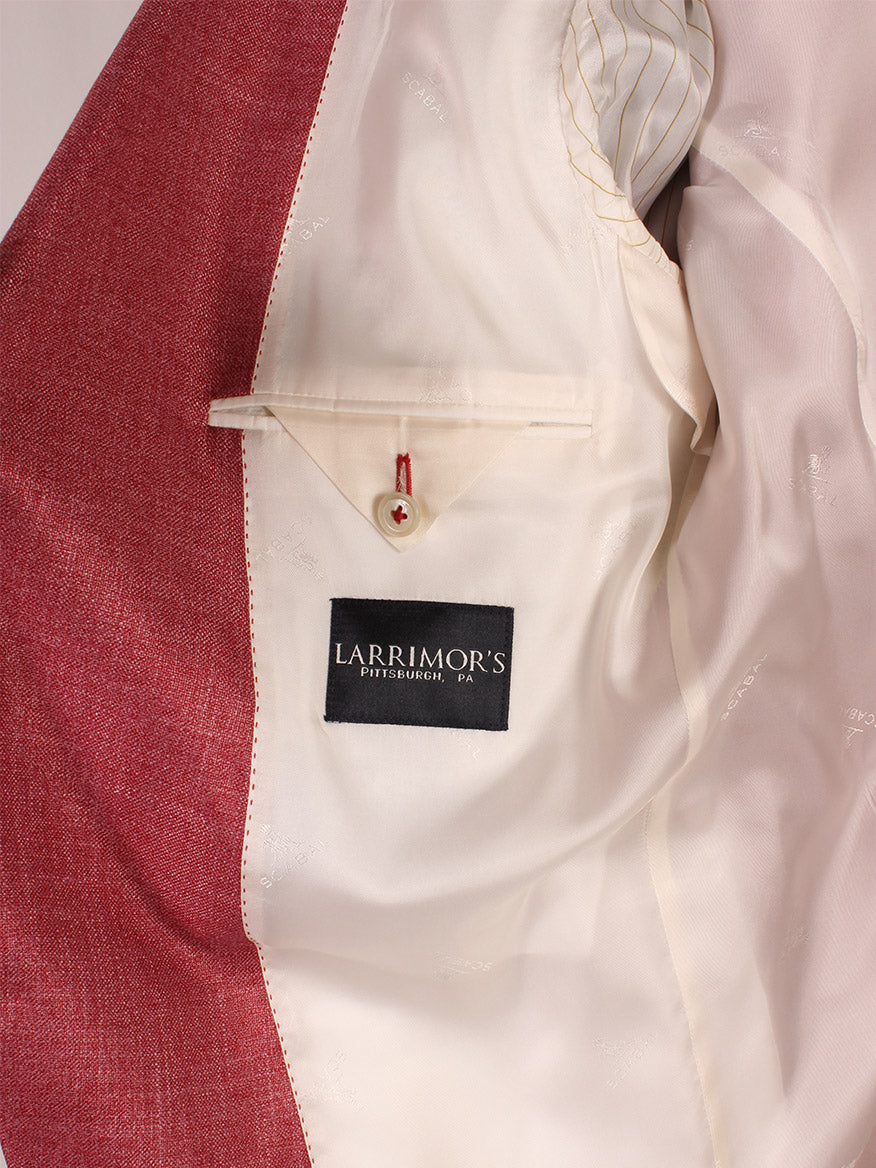 Close-up of a garment label that reads "Scabal Soho Taormina Sport Jacket in Soft Red" on a custom-made sport jacket with a buttoned collar detail, crafted in Italy.