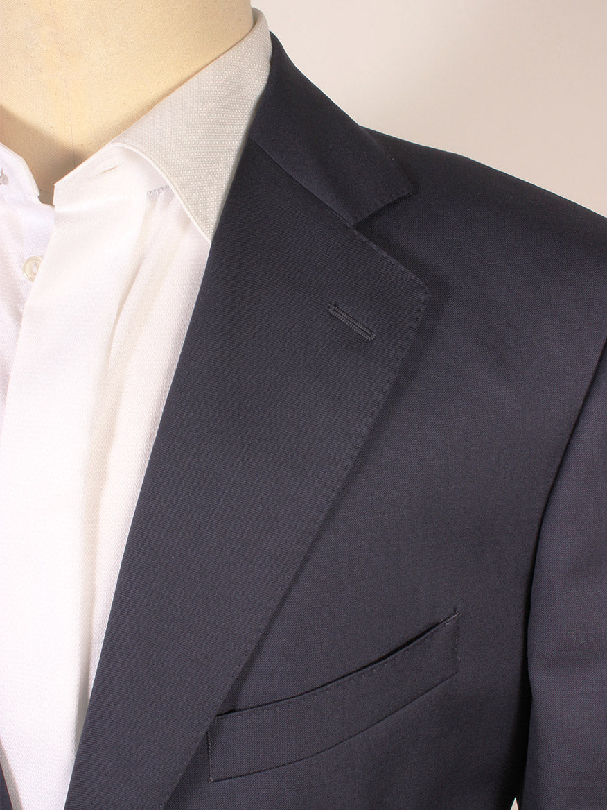 Close-up of a person wearing the Scabal Soho Super 100s Wool Suit in Navy over a white dress shirt, highlighting the lapel, collar, and part of the chest pocket.