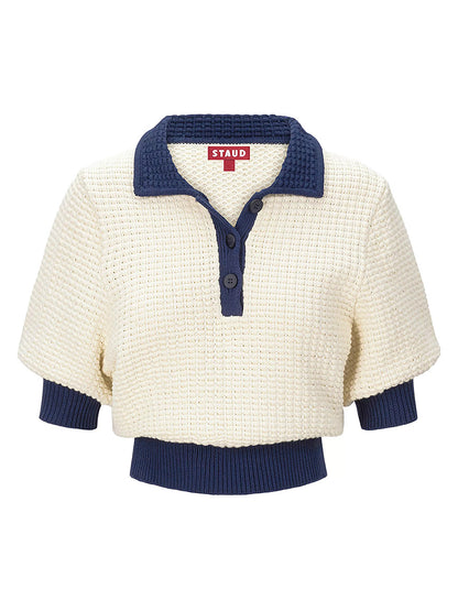 The STAUD Altea Sweater in Ivory/Navy is a cream cotton waffle-knit short-sleeve polo top with a navy collar and cuffs, featuring a button-up neckline and a red "STAUD" label.