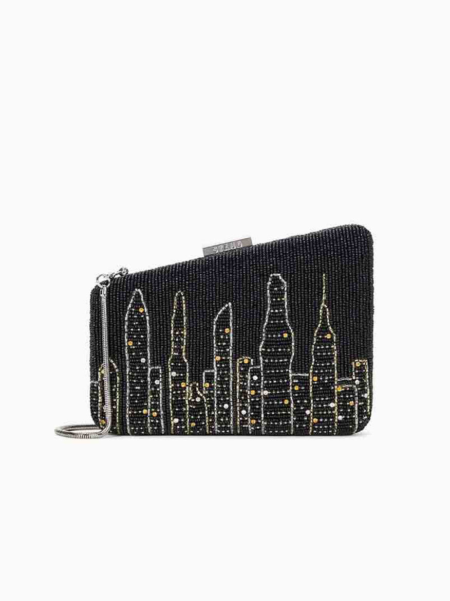 A STAUD Carmella Beaded Clutch showcasing a black beaded design with an embroidered NYC skyline and a convenient wrist strap.