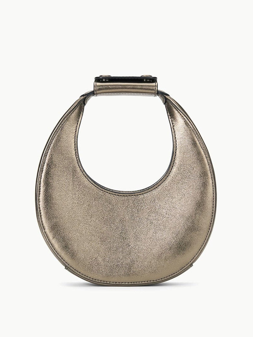 The STAUD Goodnight Moon Bag in Aged Bronze is a crescent-shaped evening bag with a smooth metallic texture and short handle, featuring an optional leather shoulder strap for versatile styling.