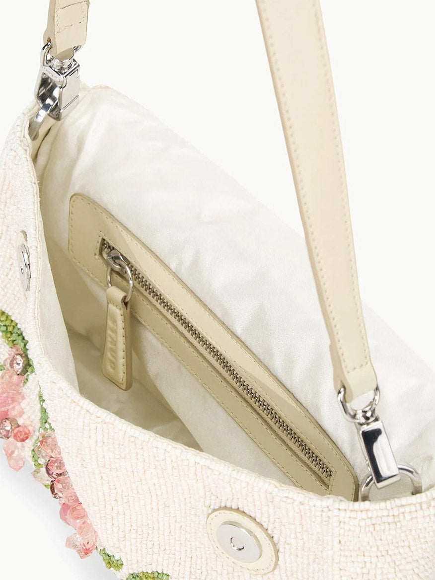 STAUD's Timmy Shoulder Bag in Magnolia is crafted with a floral bead design and includes a lined interior with a zipper pocket. It provides versatility through its removable leather strap and secures your essentials with a magnetic snap closure.