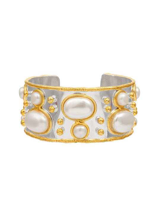 The Sylvia Toledano Cuff Byzantine in Silver Pearl is a stunning wide silver band bracelet, elegantly adorned with large oval and round white pearls, and accented by small gold beads.