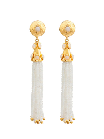 Introducing the Sylvia Toledano Earrings Gio in Moonstone: a pair of brass gilded with fine gold earrings featuring a round stud adorned with moonstones and long tassels made of small white beads.