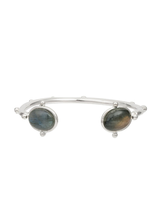 The Sylvia Toledano Bracelet Holis in Labradorite & Silver, featuring two oval labradorite stones and rounded embellishments, exudes elegance and charm. Its captivating design makes it perfect for adding a touch of sophistication to any outfit.