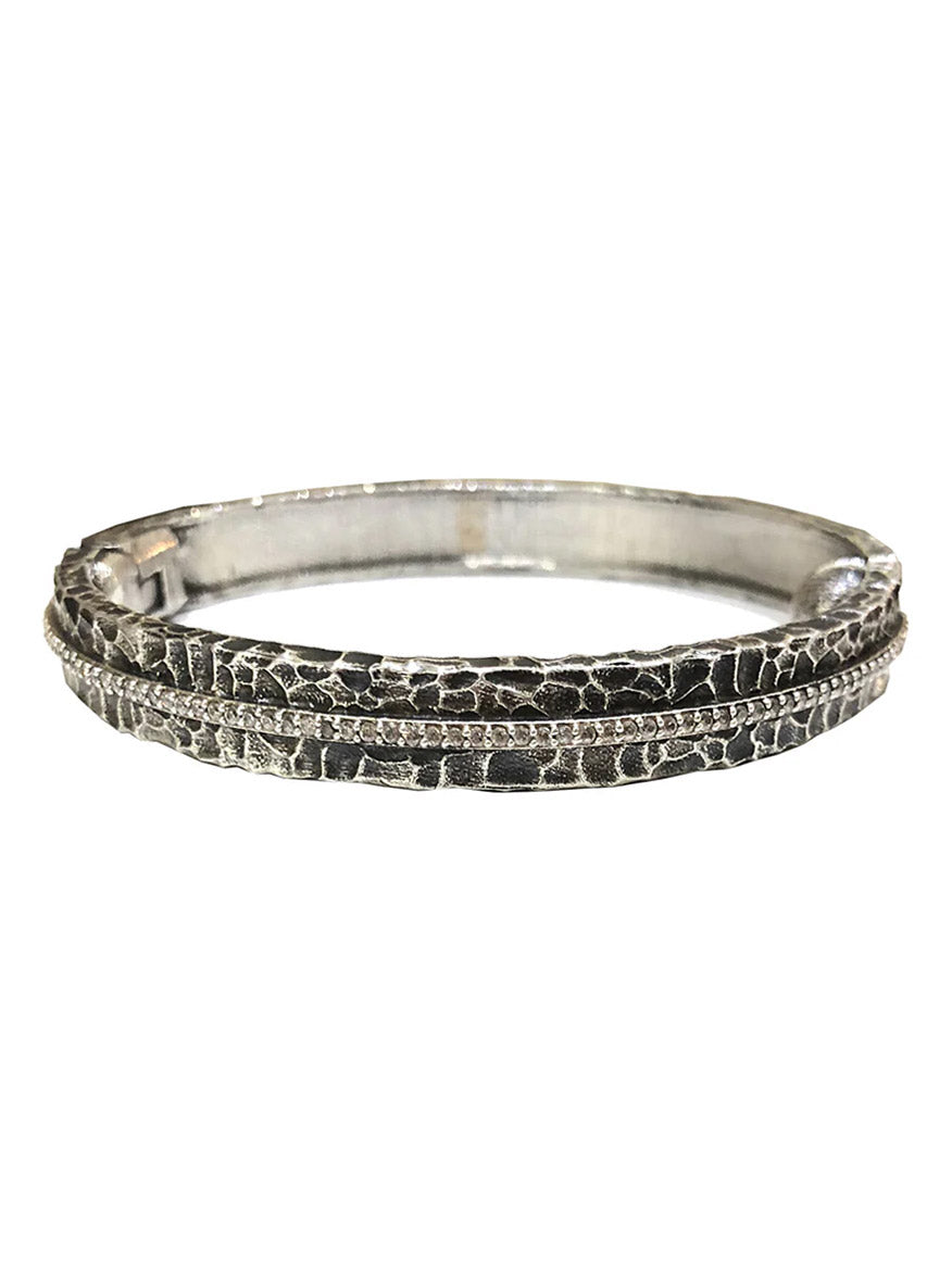 Tat2 Designs Egy Crystal Line Bangle in Vintage Silver features a raised, cracked pattern accented by a fine line of sparkling Cubic Zirconia through the center and is finished with a secure magnetic hinge closure.