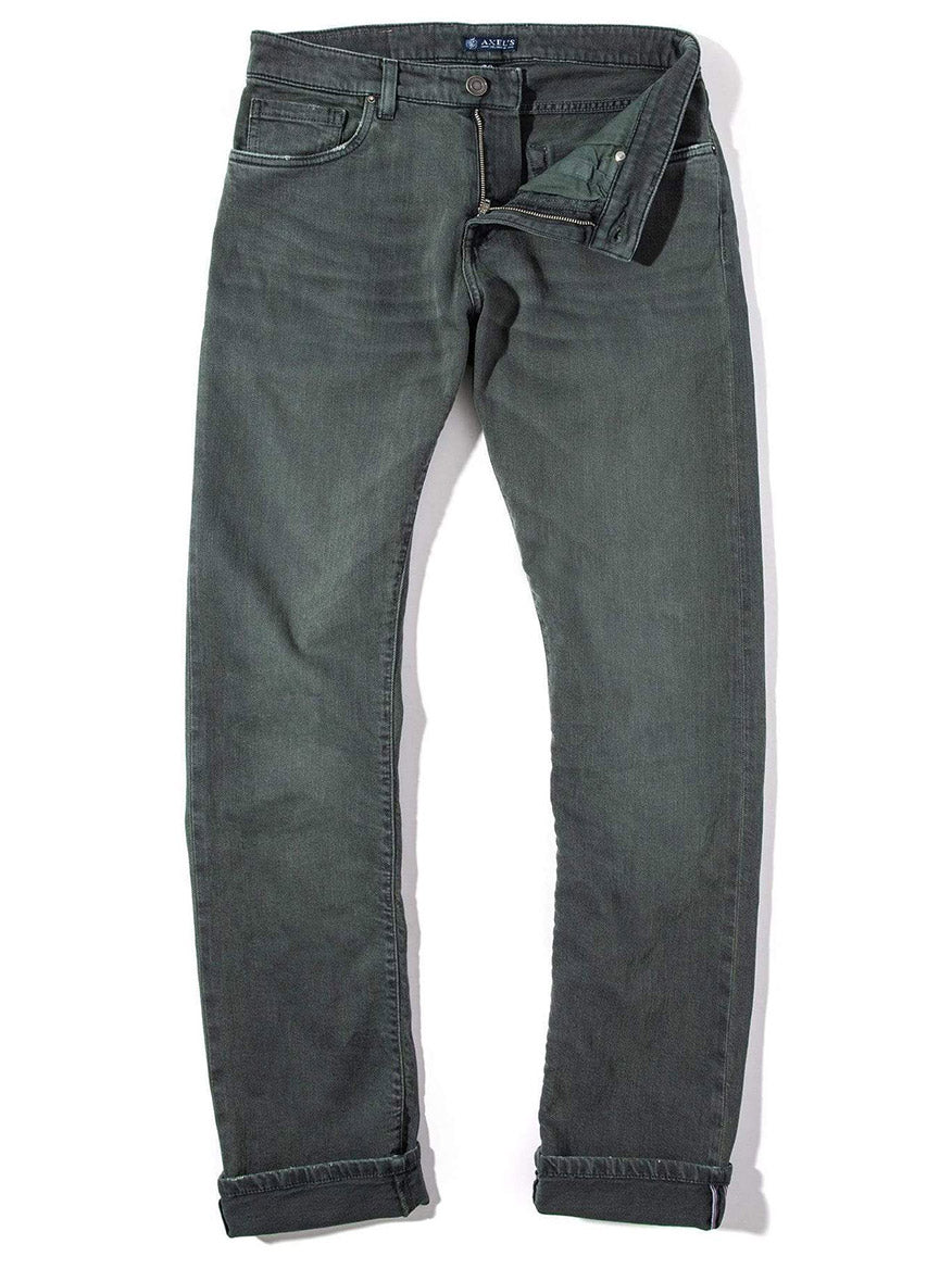 A pair of Teleria Zed Cobra Selvedge Stretch Denim in Verde Loden, with the zipper partially open and laid flat, showcasing the exquisite craftsmanship made in Italy.