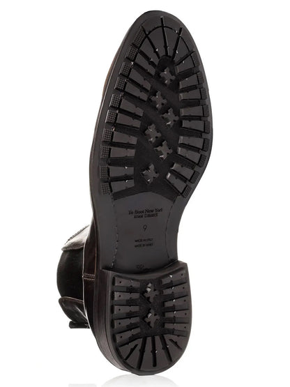 The image shows the bottom of the To Boot New York Largo Chelsea Boot in Moro, a handcrafted Italian black leather Chelsea boot, featuring a textured rubber sole with various geometric tread patterns.
