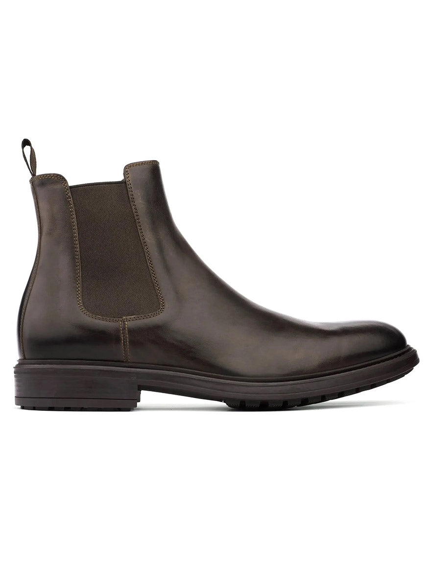 The To Boot New York Largo Chelsea Boot in Moro is a brown leather Chelsea boot, handcrafted in Italy, featuring a round toe, elastic side panel, and pull tab at the back. It is shown in a left side profile against a white background.