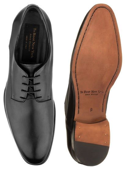 A pair of To Boot New York Blakeley in Black crafted from fine Italian calfskin, one shown from the top and the other from the side displaying the classic oxford design and a tan leather sole.