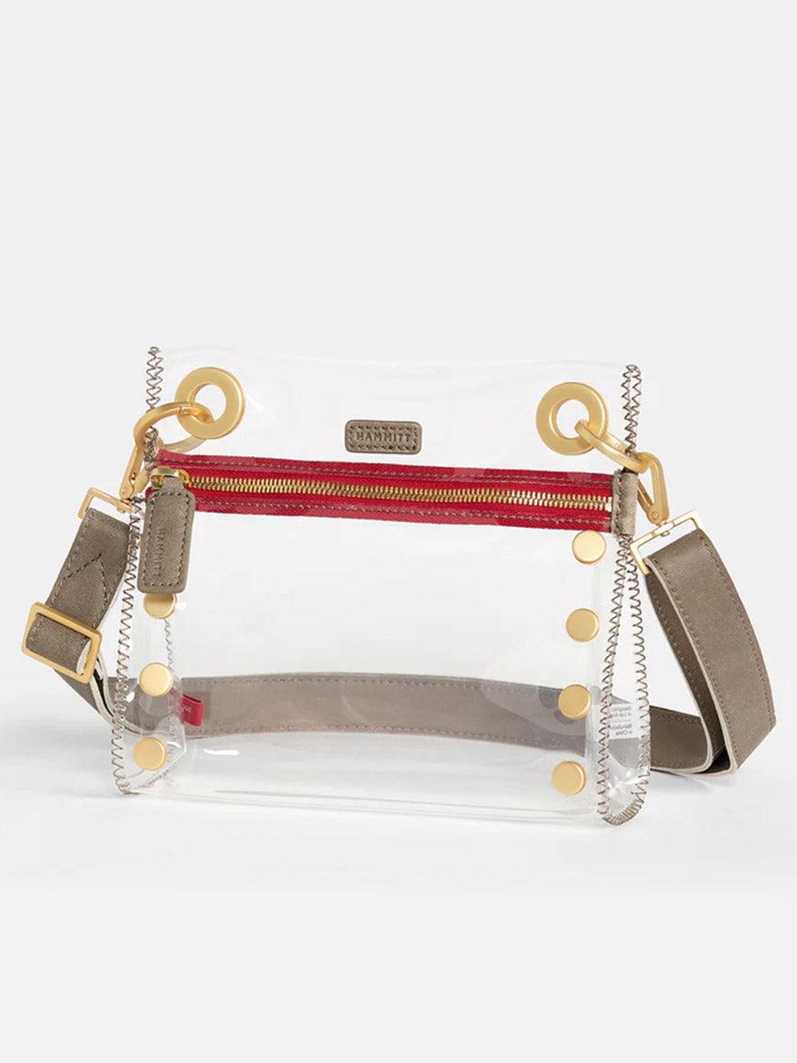 Introducing the Hammitt Los Angeles Tony Small Crossbody Bag in Clear Pewter, featuring gold-tone hardware, a red front zipper, TPU and leather trim, and an adjustable beige crossbody strap. Perfectly stadium-approved.