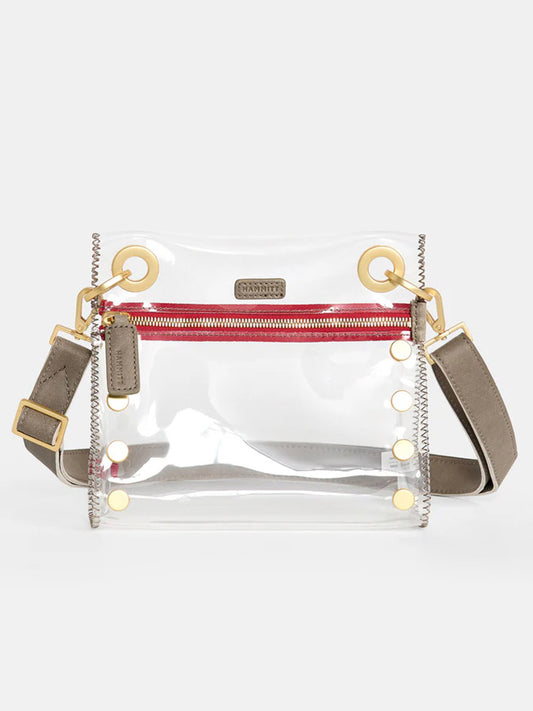 The Hammitt Los Angeles Tony Small Crossbody Bag in Clear Pewter is a stadium-approved clear PVC crossbody bag featuring gold hardware, leather trim, a red zipper pocket, an adjustable gray strap, and gold grommets.