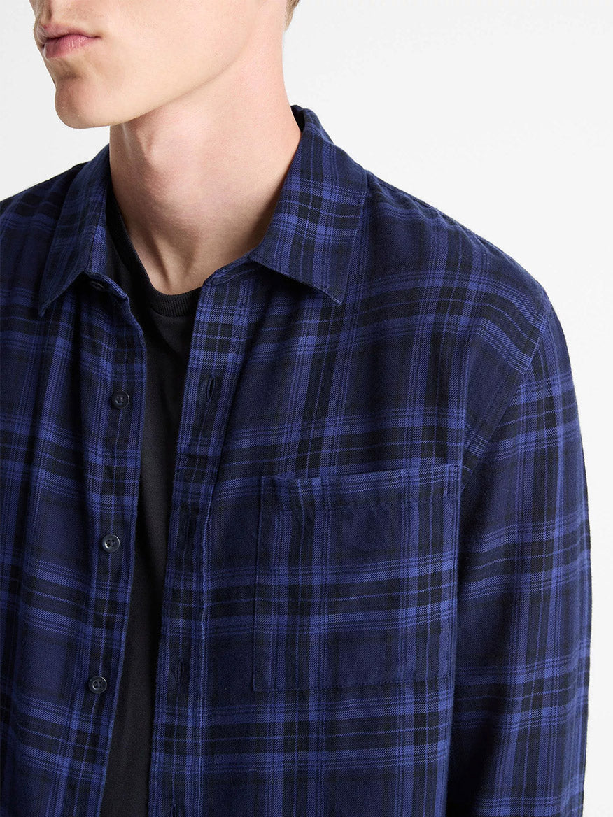 A person wearing the Vince Big Horn Plaid Cotton Button-Front Shirt in Monarch Combo, a blue and black plaid flannel, over a black t-shirt, shown from shoulders to chest.
