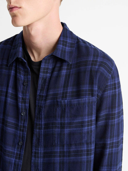 A person wearing the Vince Big Horn Plaid Cotton Button-Front Shirt in Monarch Combo, a blue and black plaid flannel, over a black t-shirt, shown from shoulders to chest.