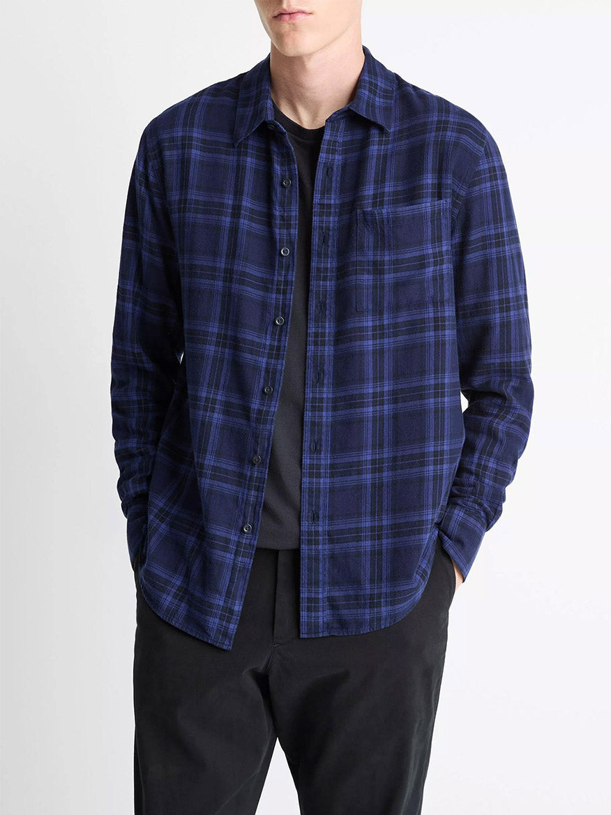 A person wearing the Vince Big Horn Plaid Cotton Button-Front Shirt in Monarch Combo over a black t-shirt and black pants, hands in pockets.