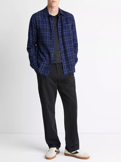 A person stands against a plain background wearing the Vince Big Horn Plaid Cotton Button-Front Shirt in Monarch Combo over a black t-shirt, black pants, and white sneakers with gum soles.