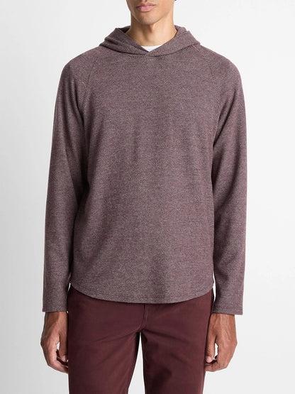 A man wears the Vince Broken Twill Pullover Hoodie in Port/Heather Grey, made from a soft modal-cotton blend, paired with matching maroon pants, standing against a plain white background.