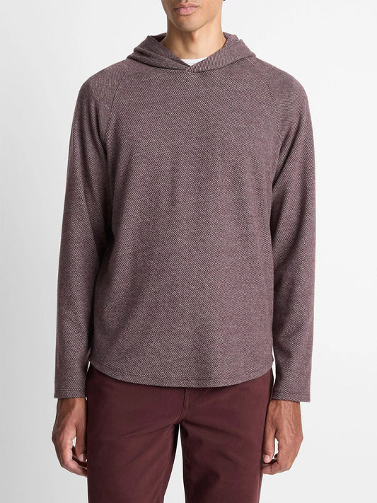 A man wears the Vince Broken Twill Pullover Hoodie in Port/Heather Grey, made from a soft modal-cotton blend, paired with matching maroon pants, standing against a plain white background.