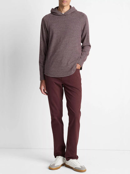 A person stands against a plain white background wearing the Vince Broken Twill Pullover Hoodie in Port/Heather Grey, matching maroon pants, and white sneakers with tan soles.