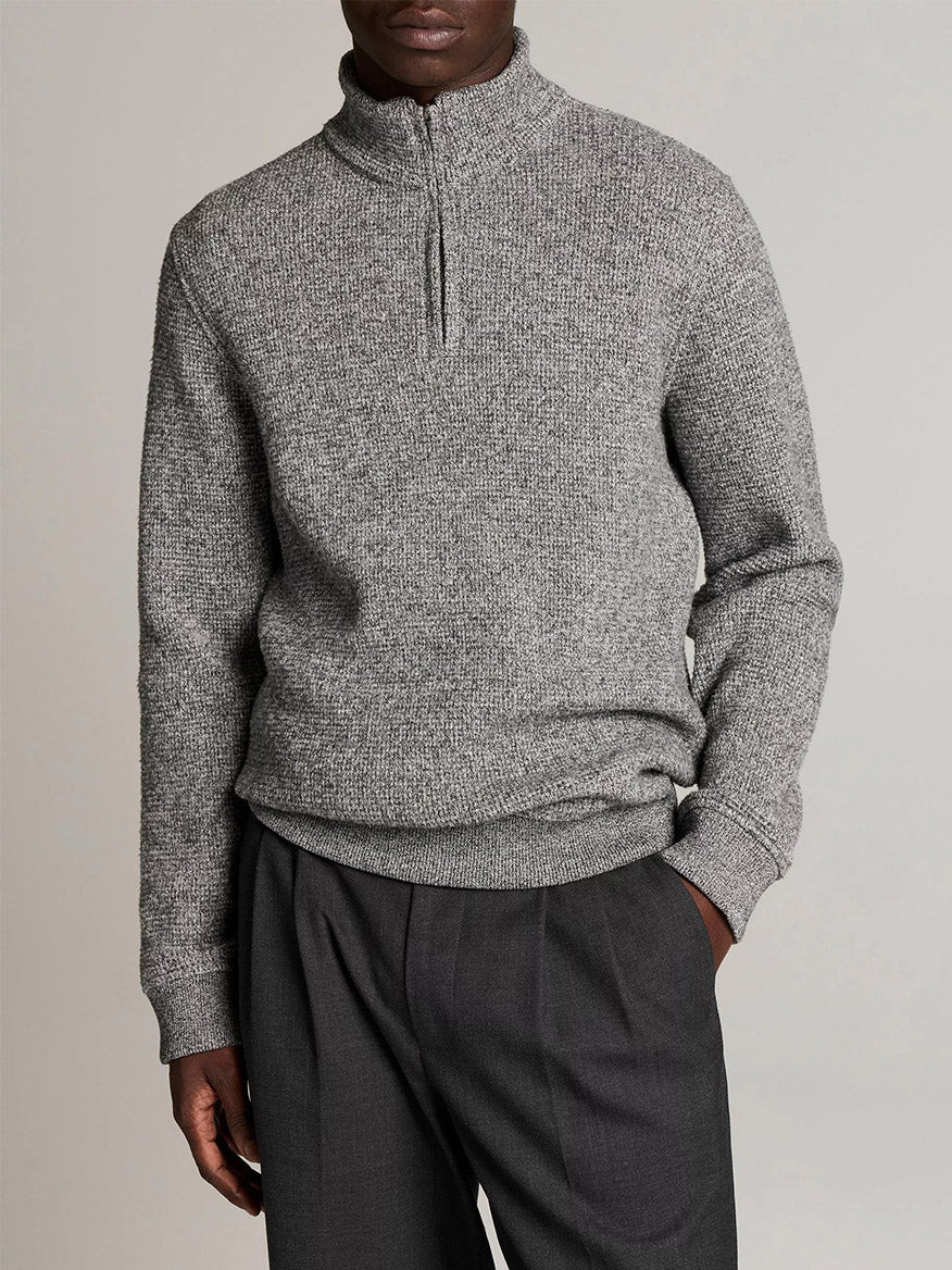 Person wears the Vince Brushed Cotton-Blend Waffle Quarter-Zip Pullover in Heather Black and dark gray trousers, standing with one hand in pocket against a plain background.